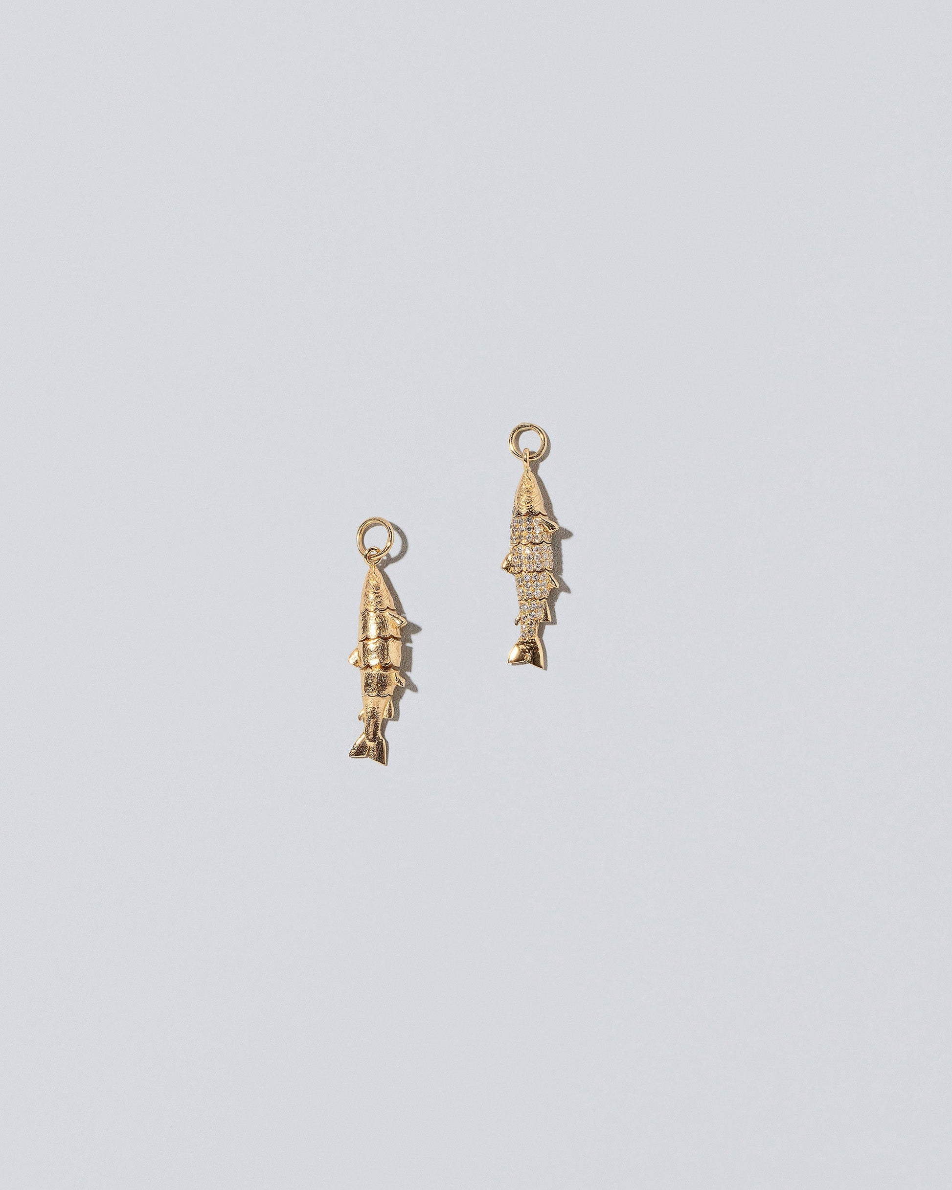 Pavé and Solid Gold Fish Charm on light color background.