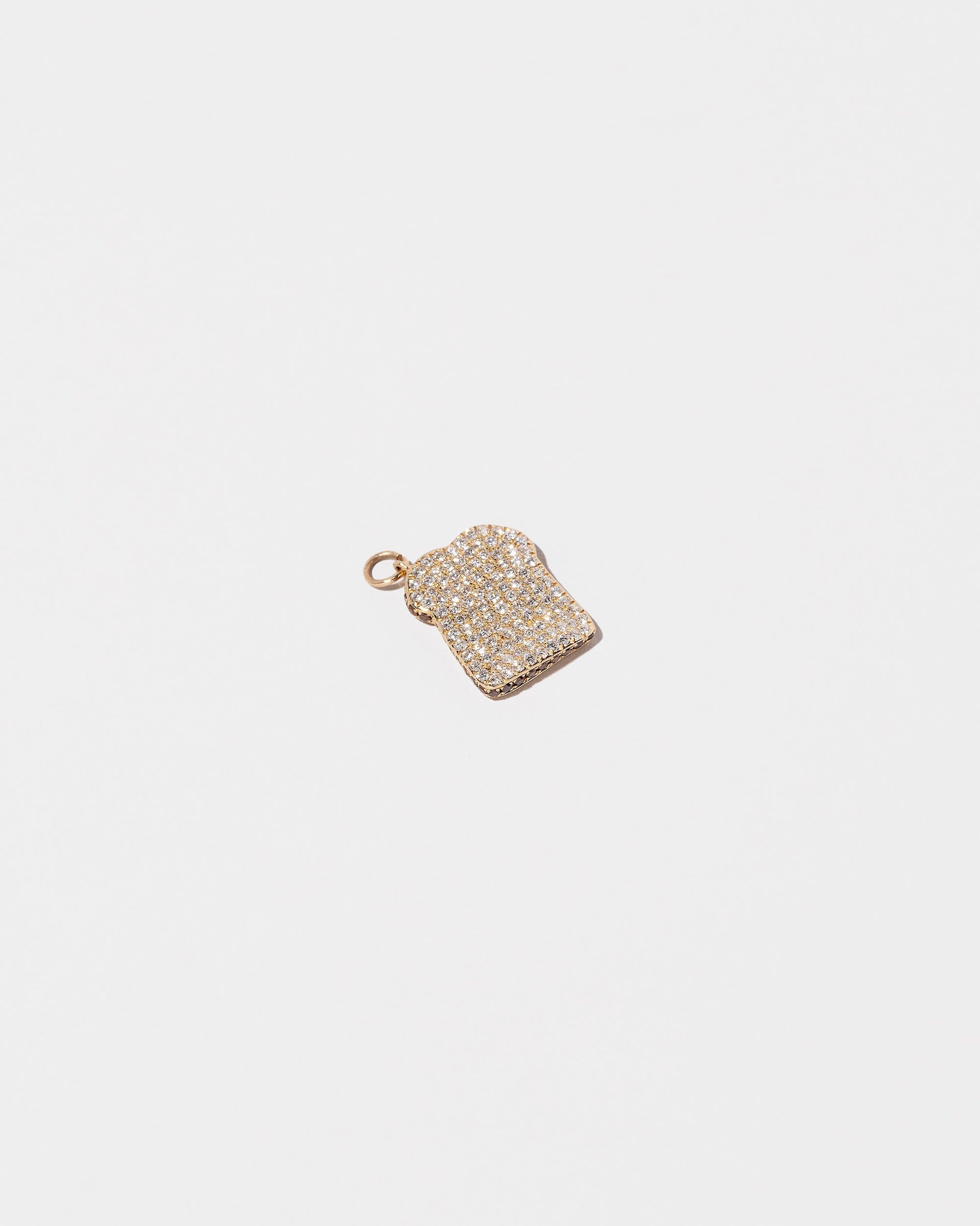 Closeup details of the Pavé Toast Charm on light color background.