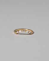 Gold Baguette Mini Curve Band on light color background.