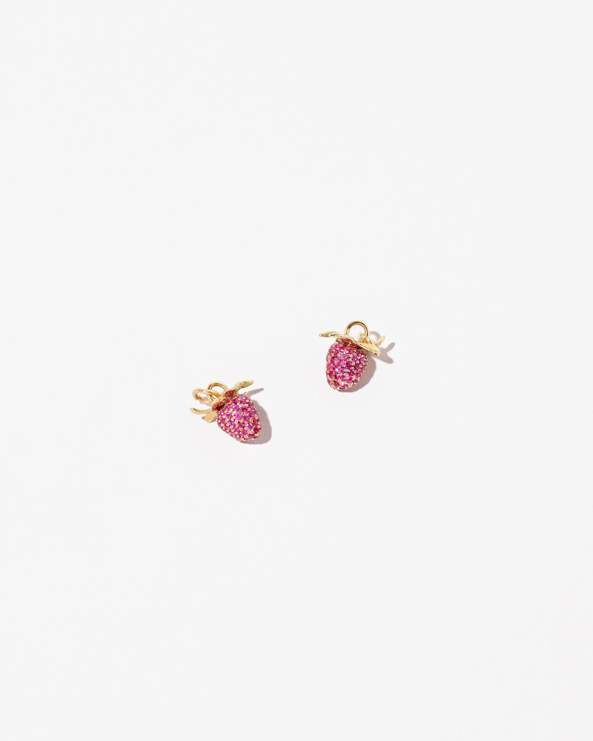 Ruby Pavé Strawberry Charms on light color background.
