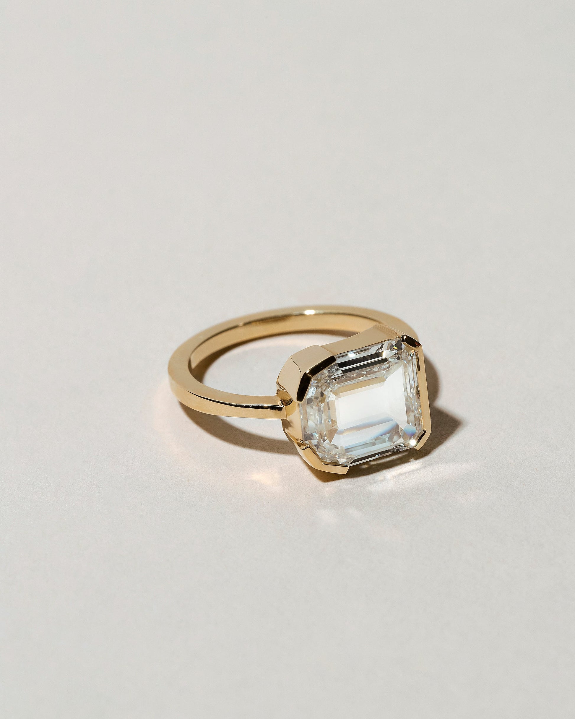 View from the side of the Shield Step Cut Diamond Ring on light color background.