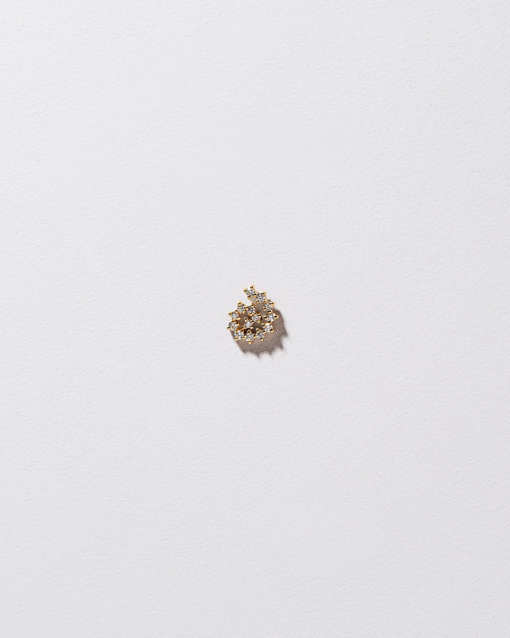 Mini White Diamond Left Spiral Stud Earring Single on light color background.