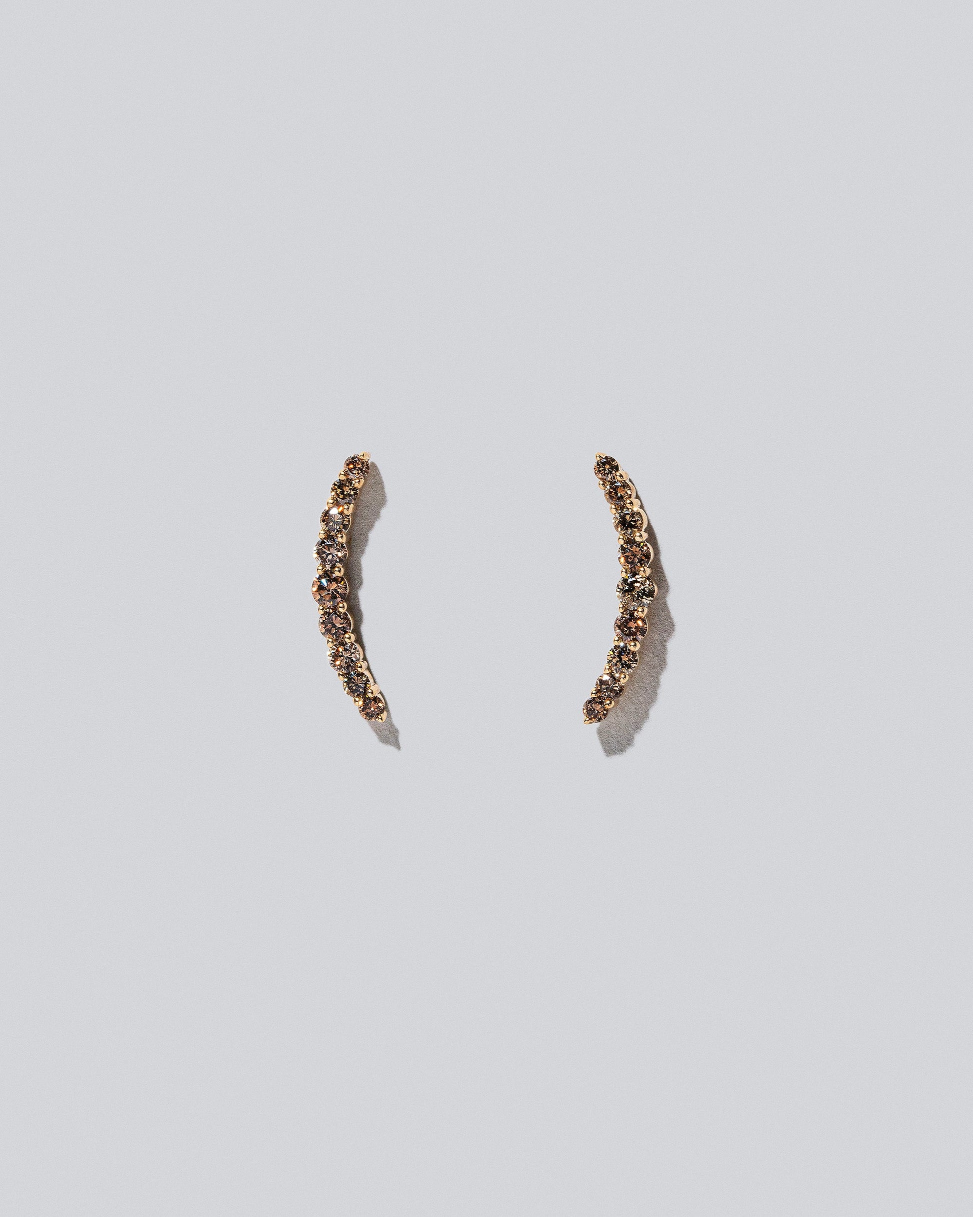 Crescent Ear Climber Stud Earrings - Cognac Diamond on light colored background.