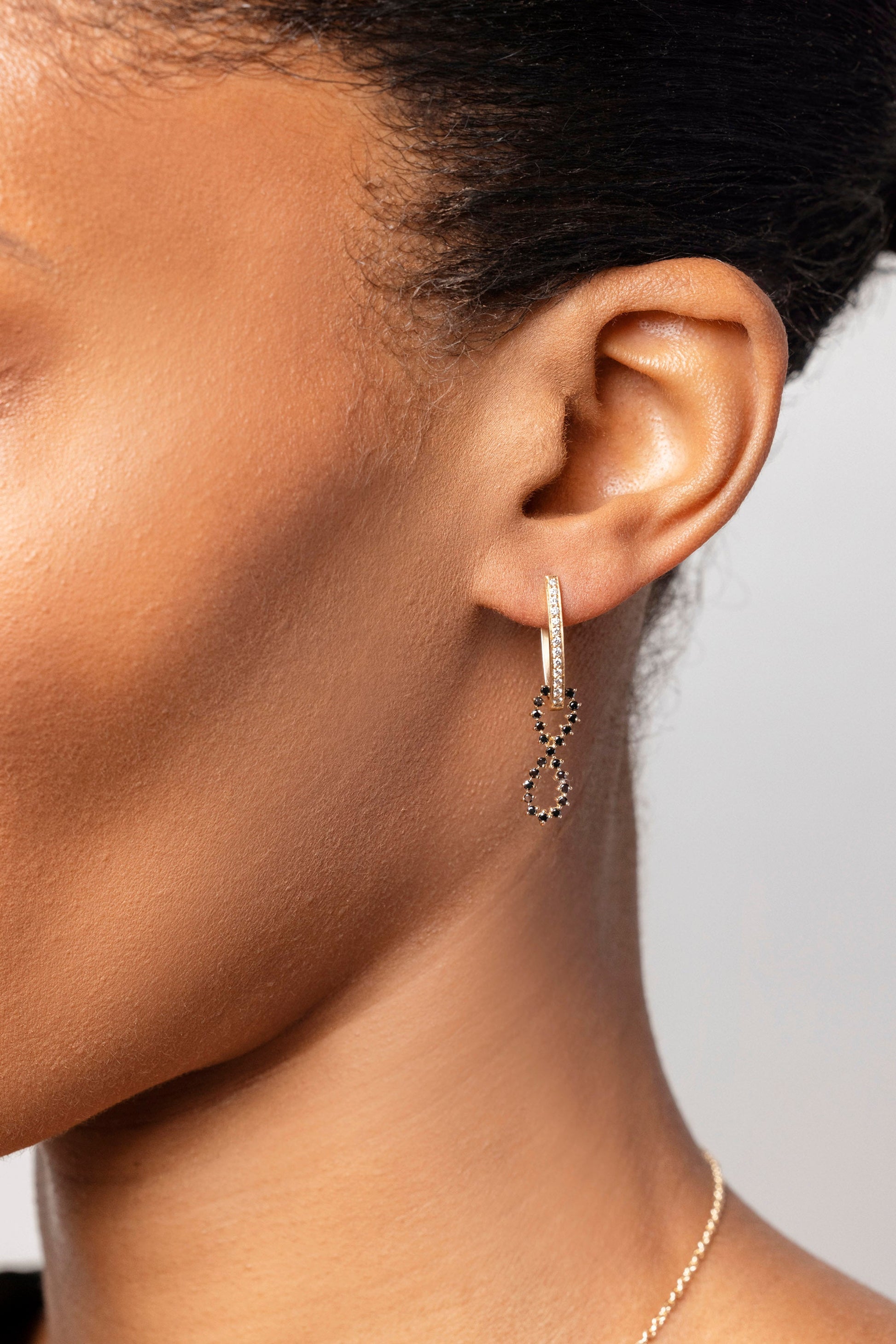Gold White Diamond Tiny Loop Hoop Earring paired with the Black Diamond Infinity Charm on model.