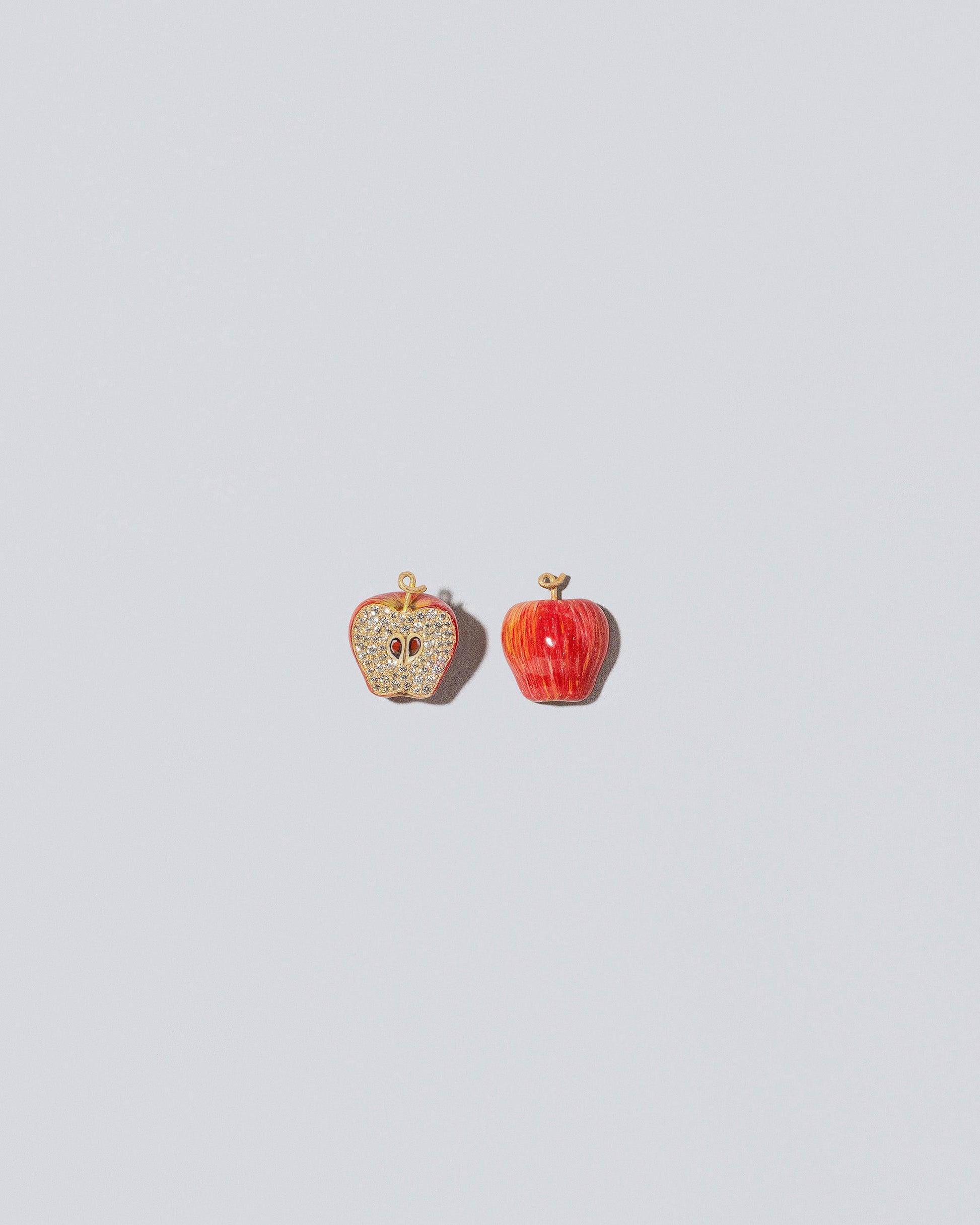 View from the front and view from the back of the Red Apple Core Charm on light color background. Charm sold individually,