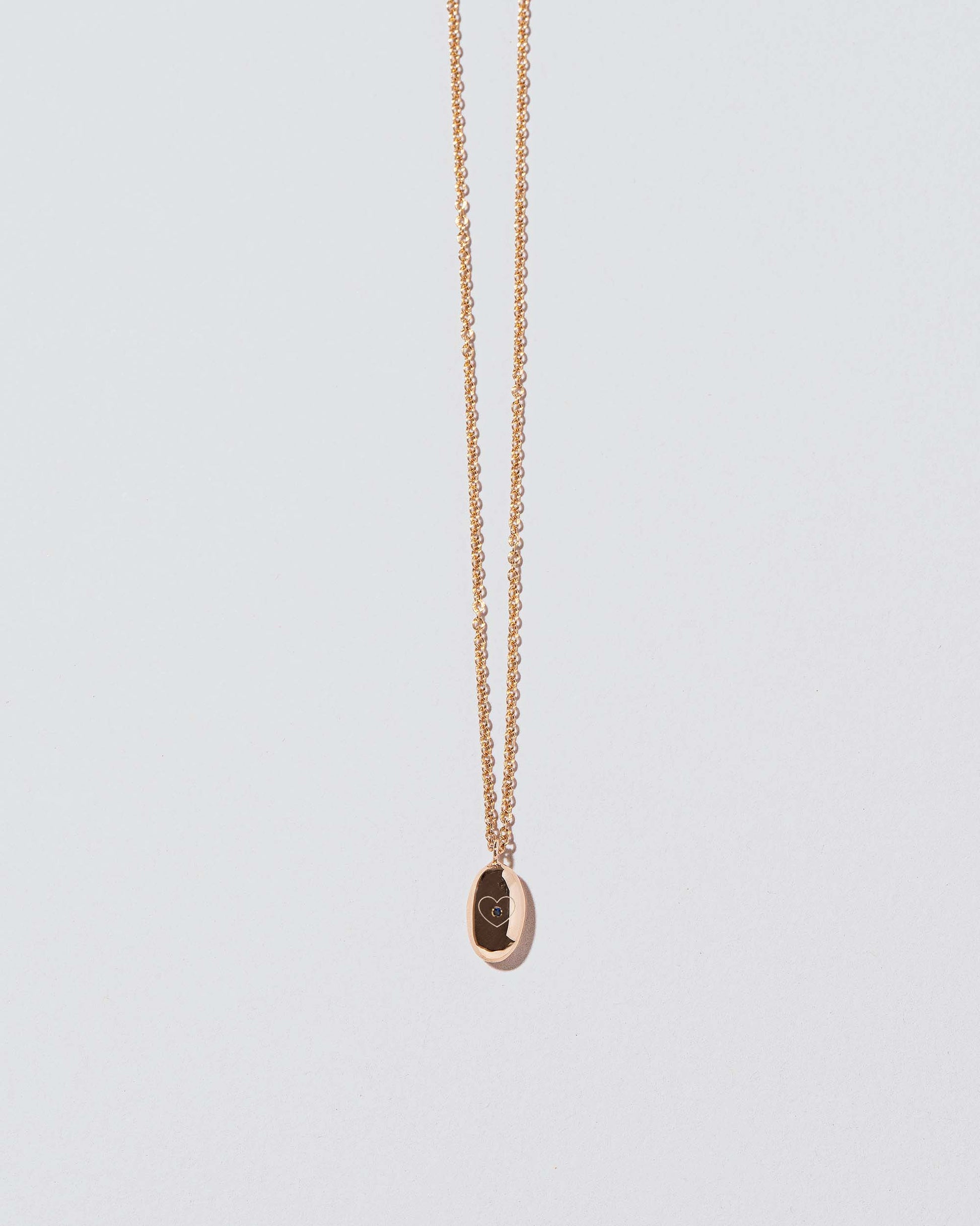 Closeup detail of Bead Time Capsule Necklace with Gemstone and Engraving added on light color background.