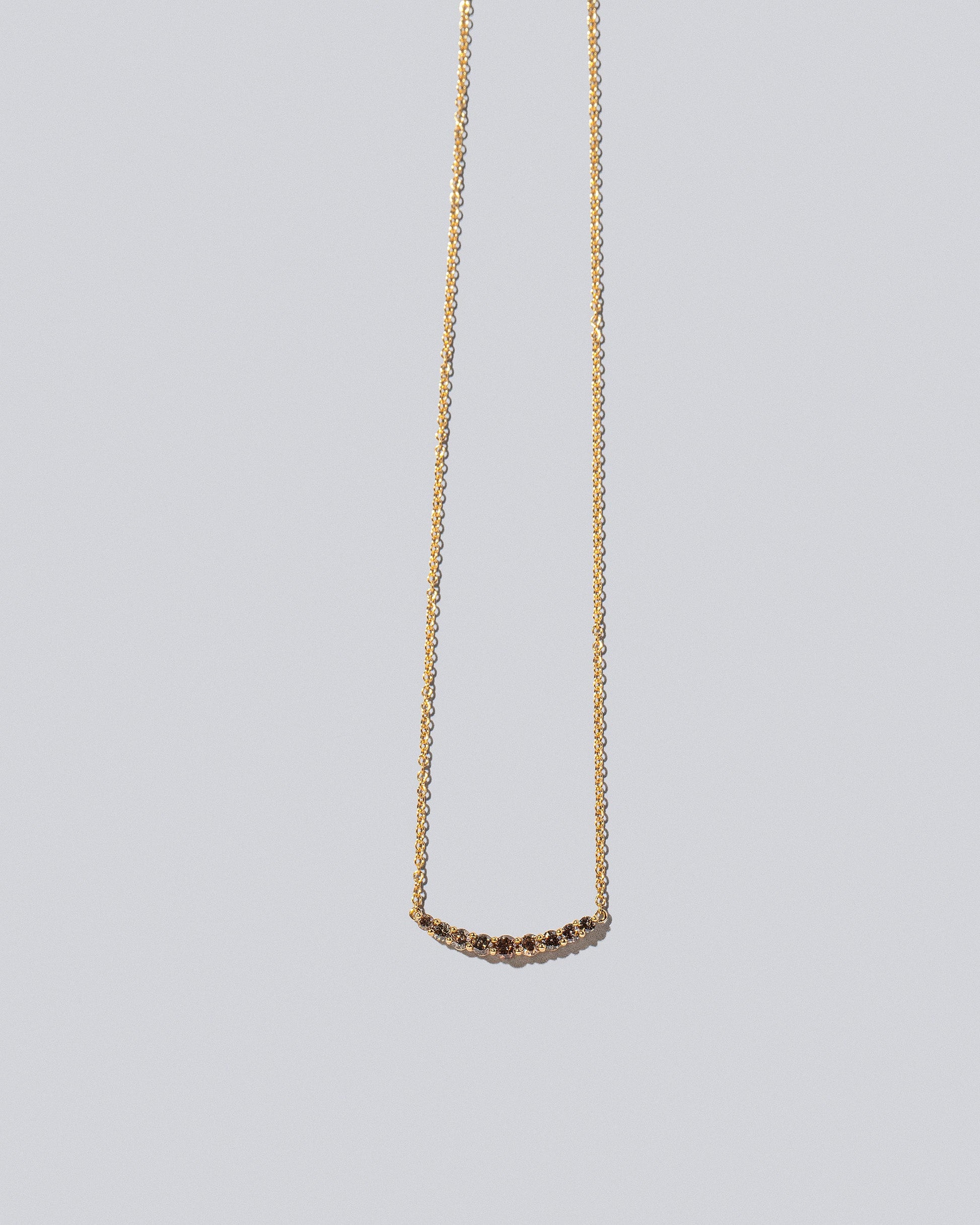 Cognac Diamond Crescent Necklace on light color background.