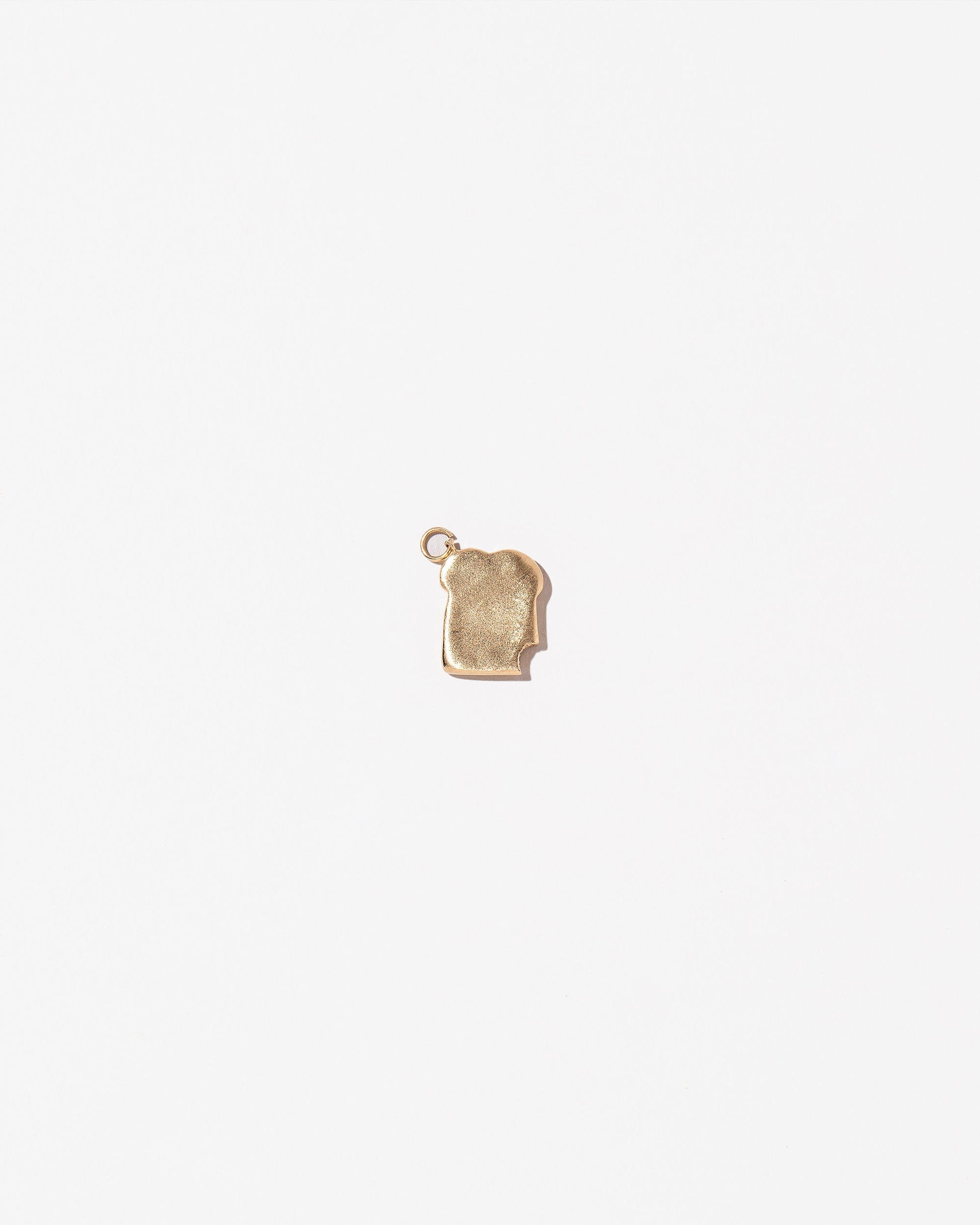 Bitten Toast Charm on light color background.