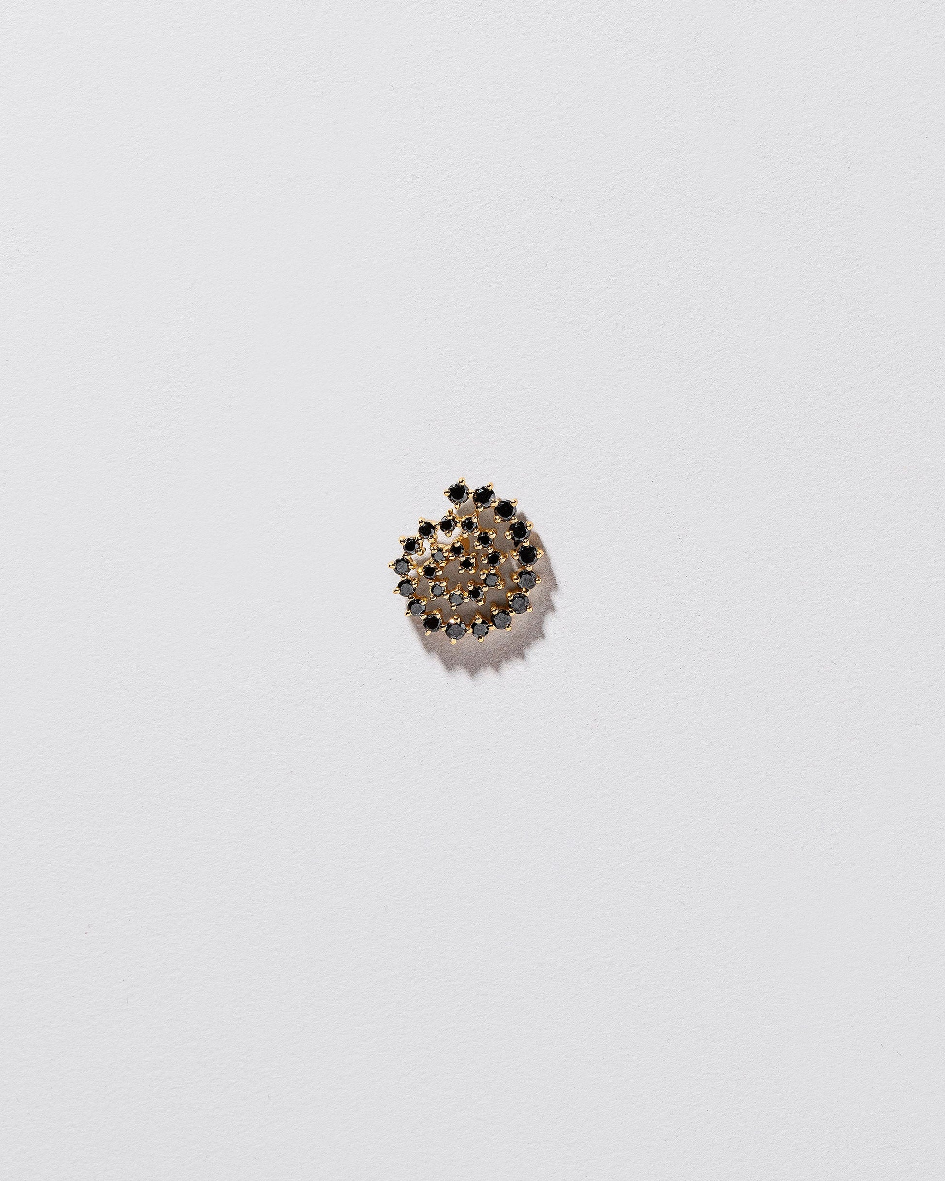 Full Black Diamond Left Spiral Stud Earring Single on light color background.