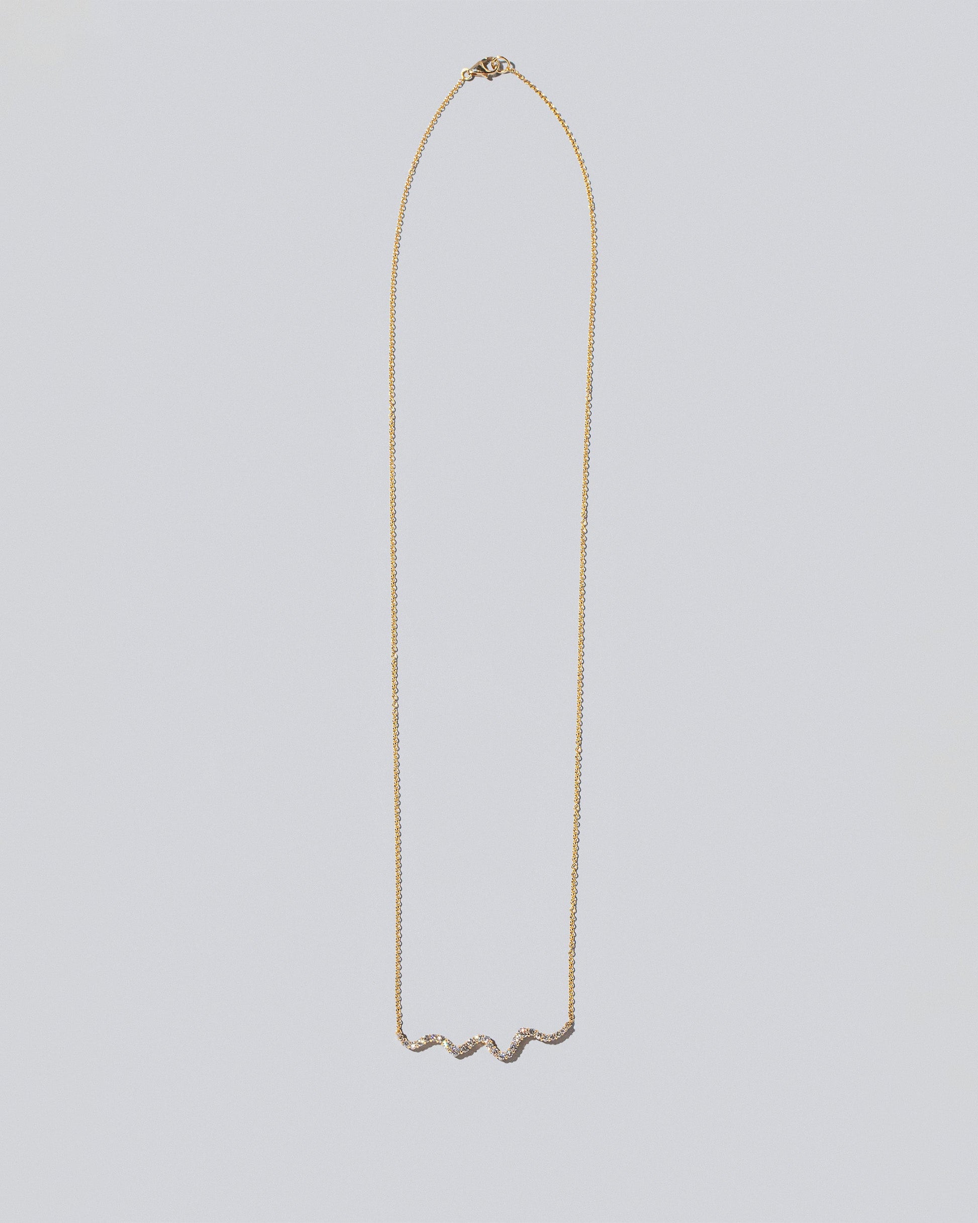 White Diamond Ripple Wave Necklace on light color background.