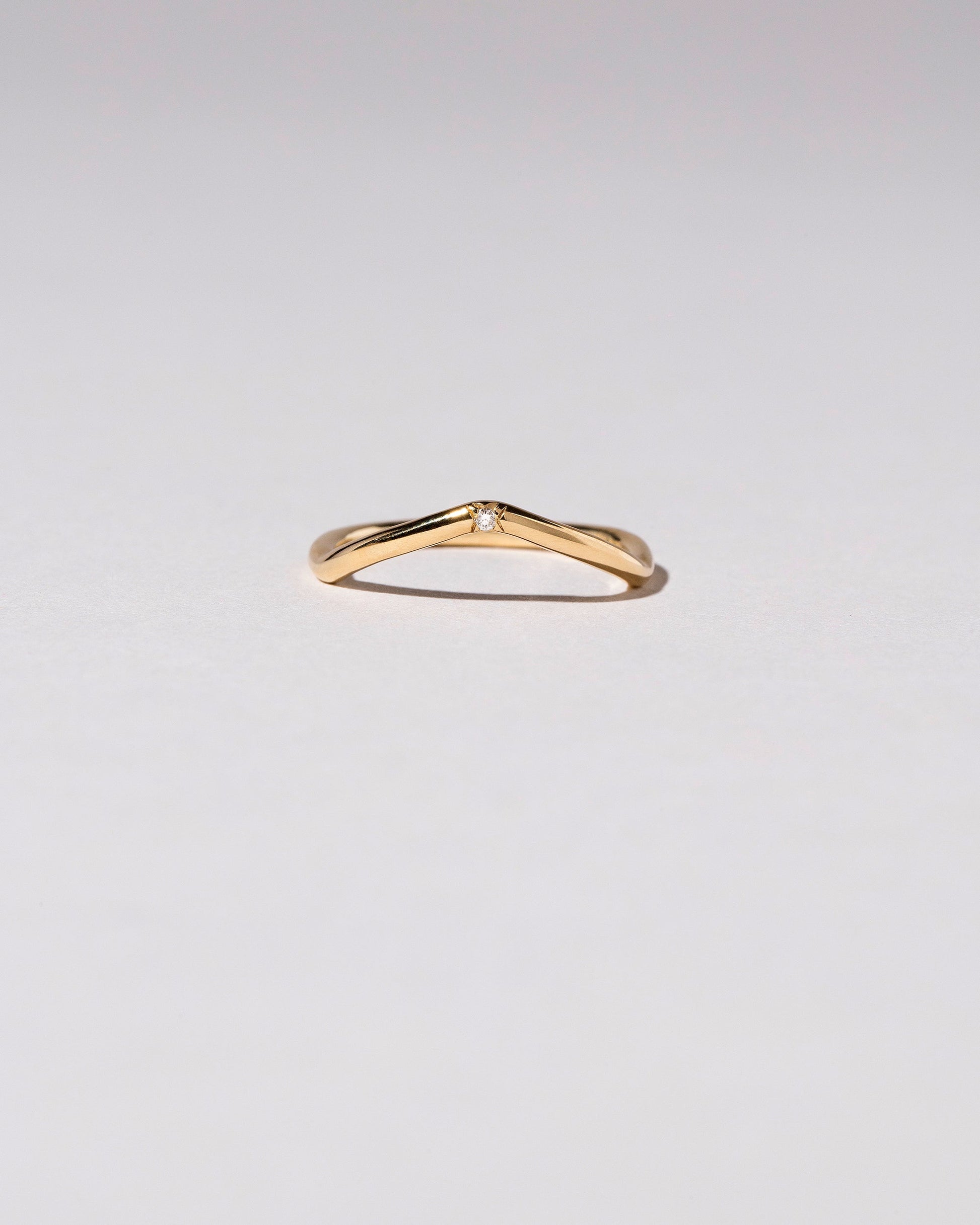 Gold Single Stone White Diamond Low Peak Band on light color background.