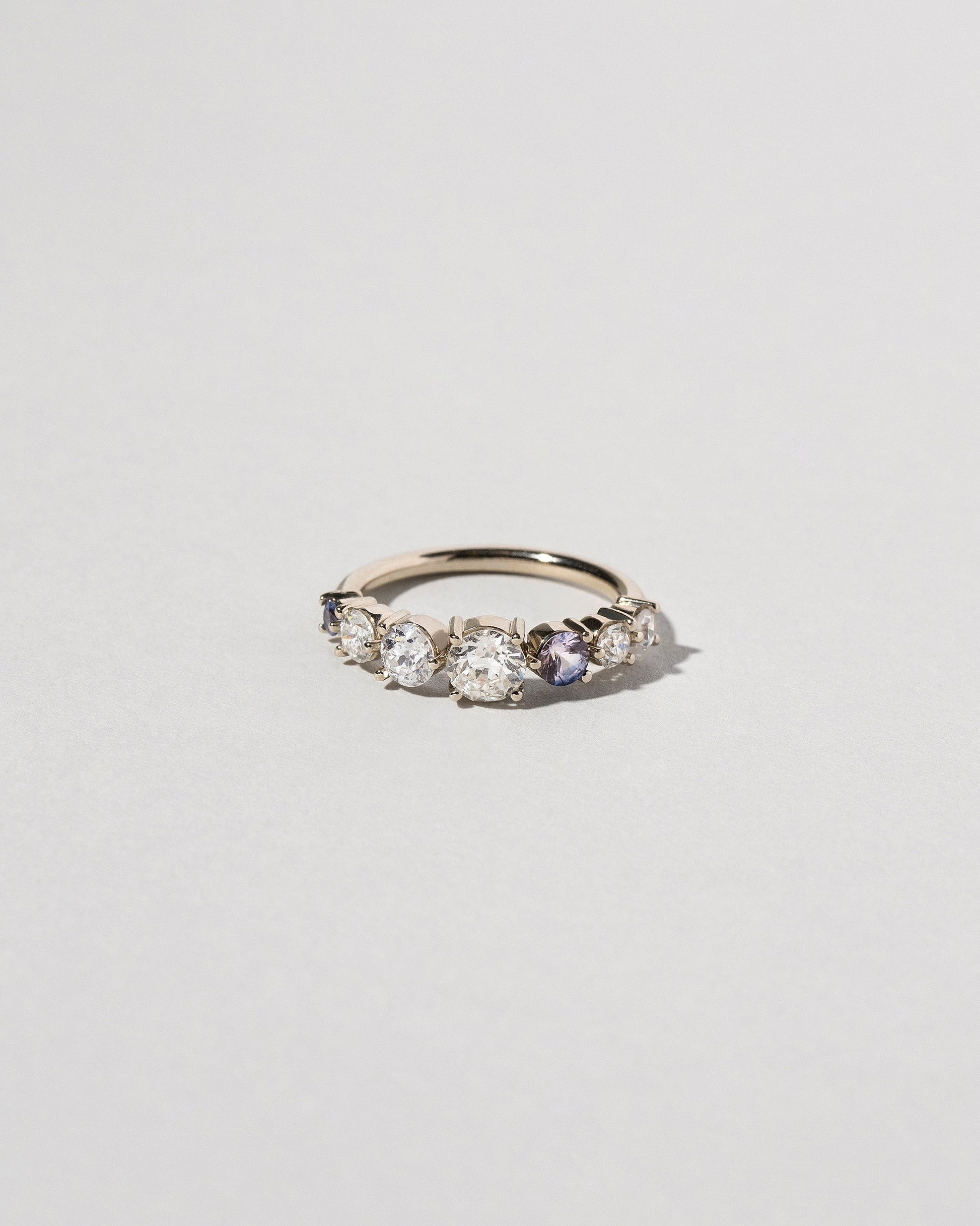 Diamond & Sapphire Line Cluster Ring on light color background.