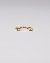 Gold Five Stone Black Diamond Mini Curve Band on light color background.