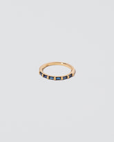 Gold Blue Sapphire Bar Baguette Band on light color background.
