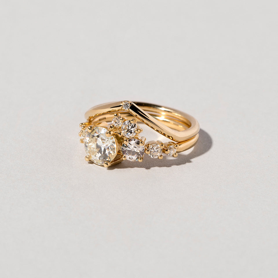 product_details::Gold White Diamond Single Stone Luna Peak Band and White Diamond Luna Ring on light color background.