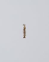 Skeletal Fish Charm on light color background.