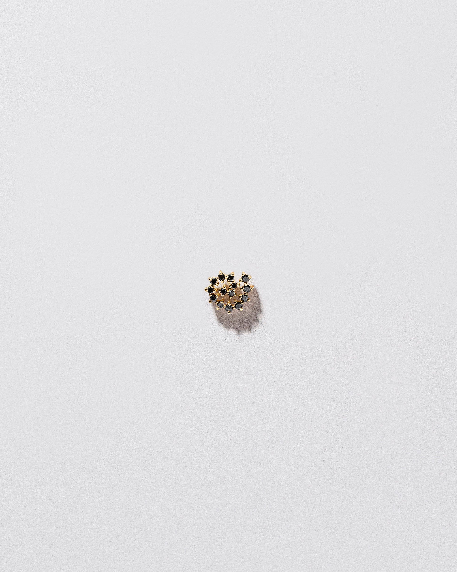 Mini Black Diamond Left Spiral Stud Earring Single on light color background.