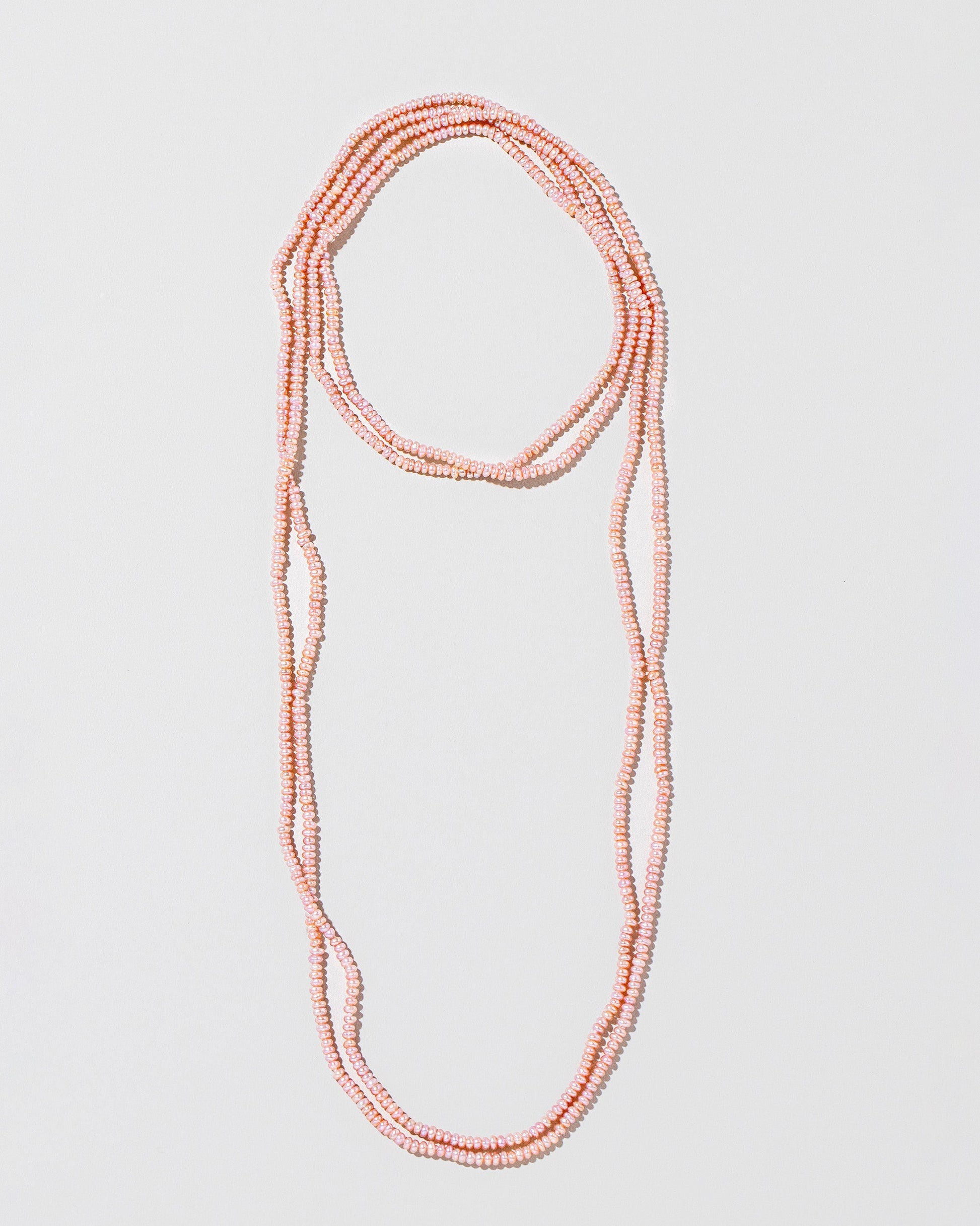 Pink Lavender Seed Pearl Rope Necklace on light color background.