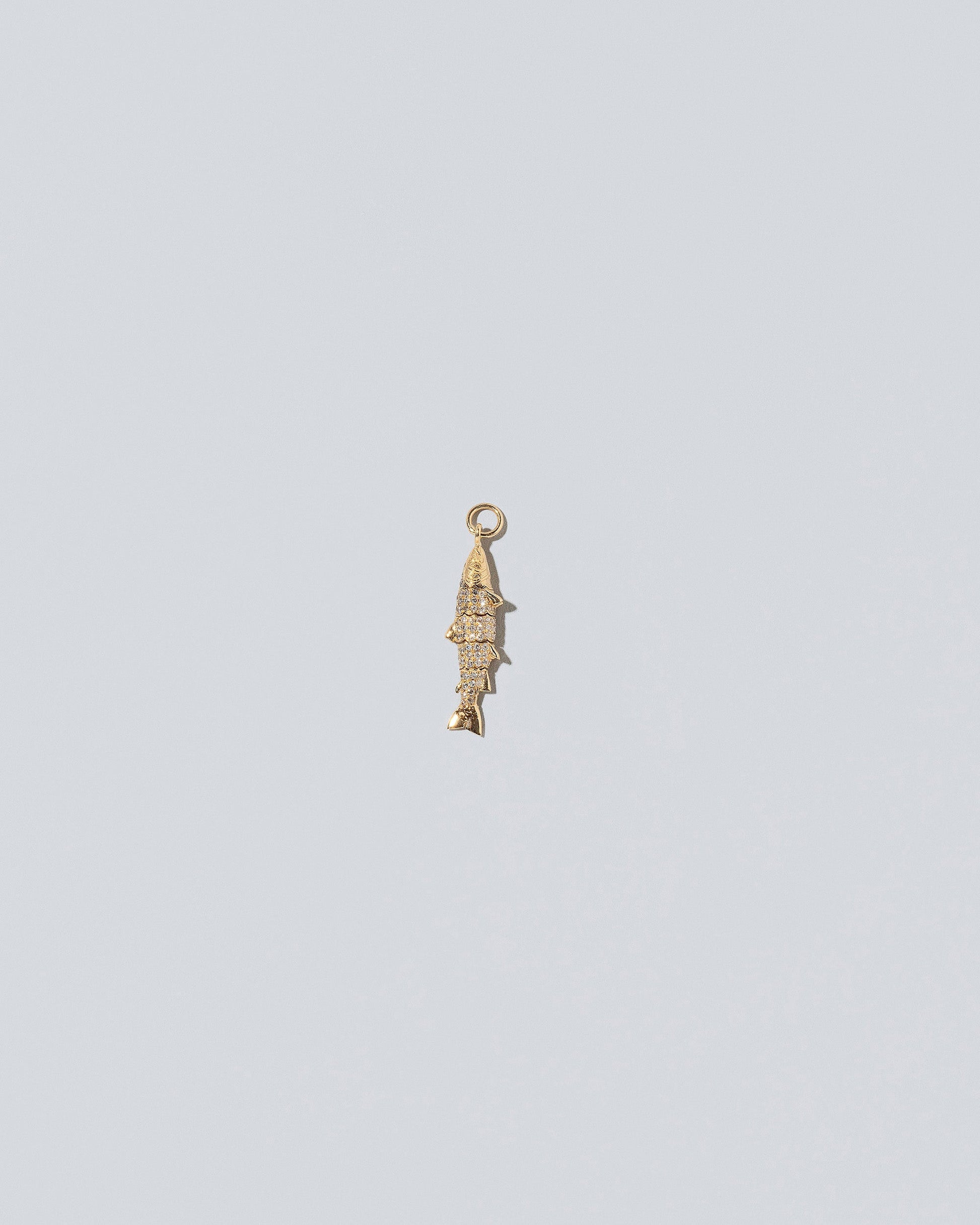 View from the back of the Pavé Fish Charm on light color background.