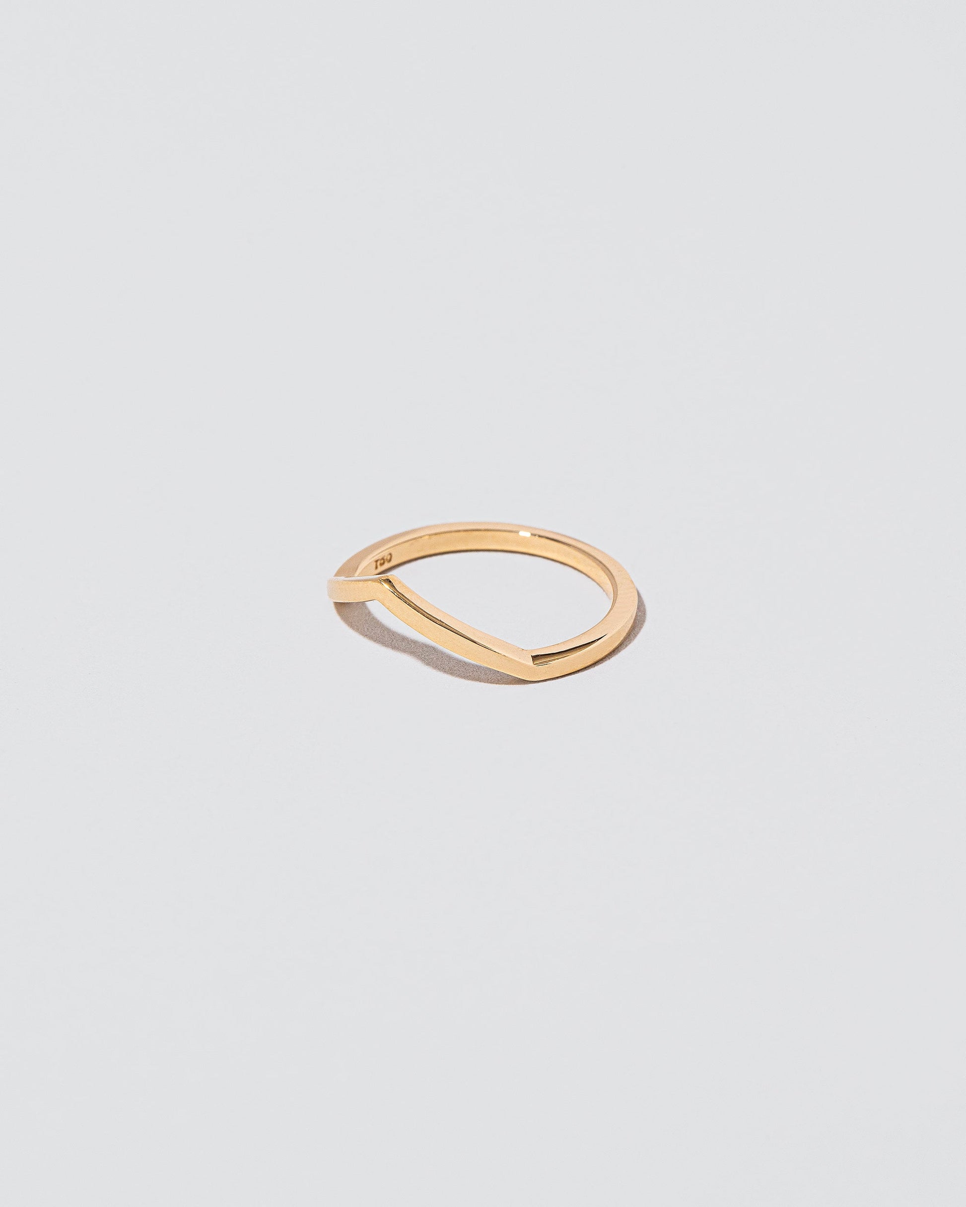 View from the side of the Gold Solid Square Wire Low Peak Band on light colored background.