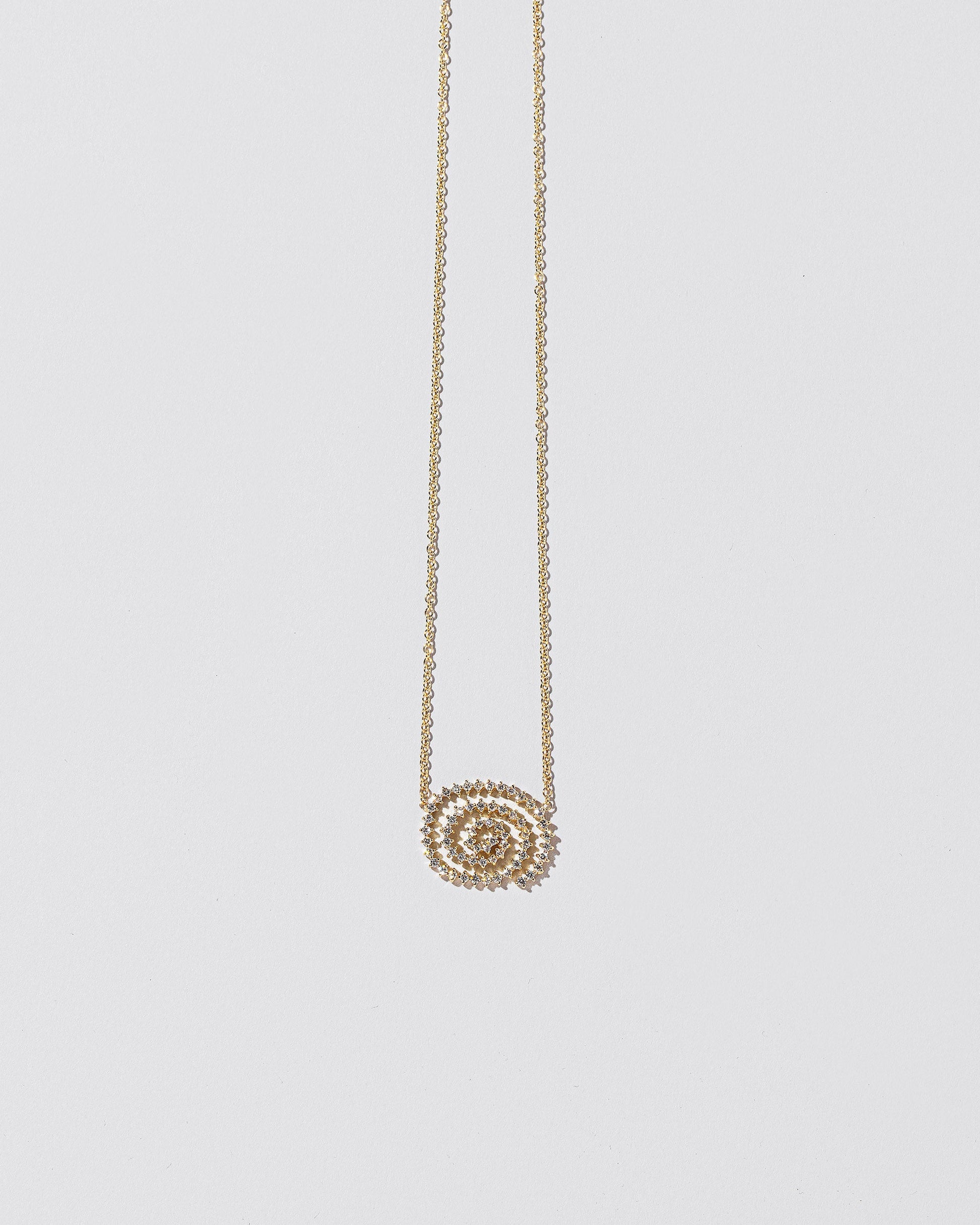 White Diamond Cycle of Rebirth Necklace on light color background.