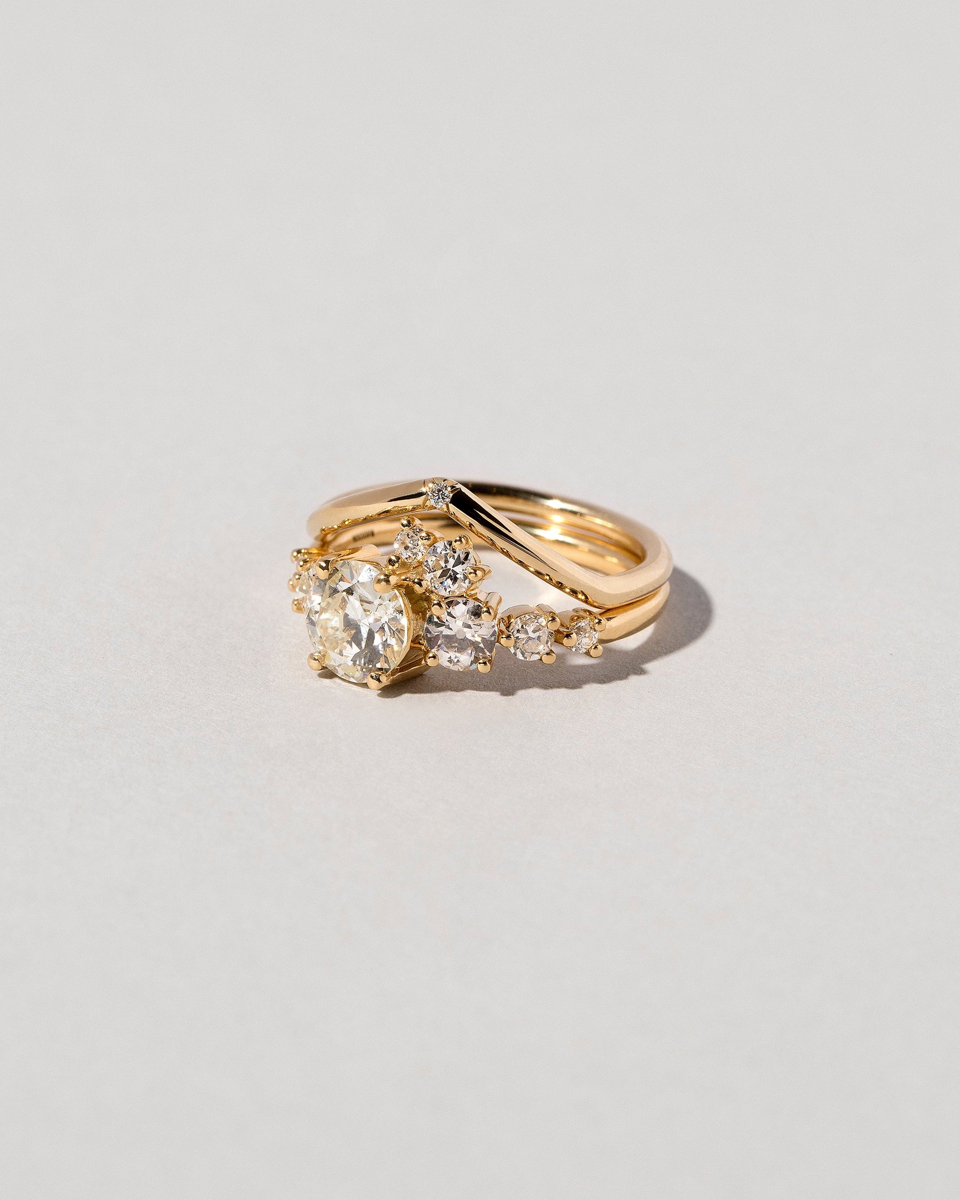 Gold White Diamond Single Stone Luna Peak Band and White Diamond Luna Ring on light color background.