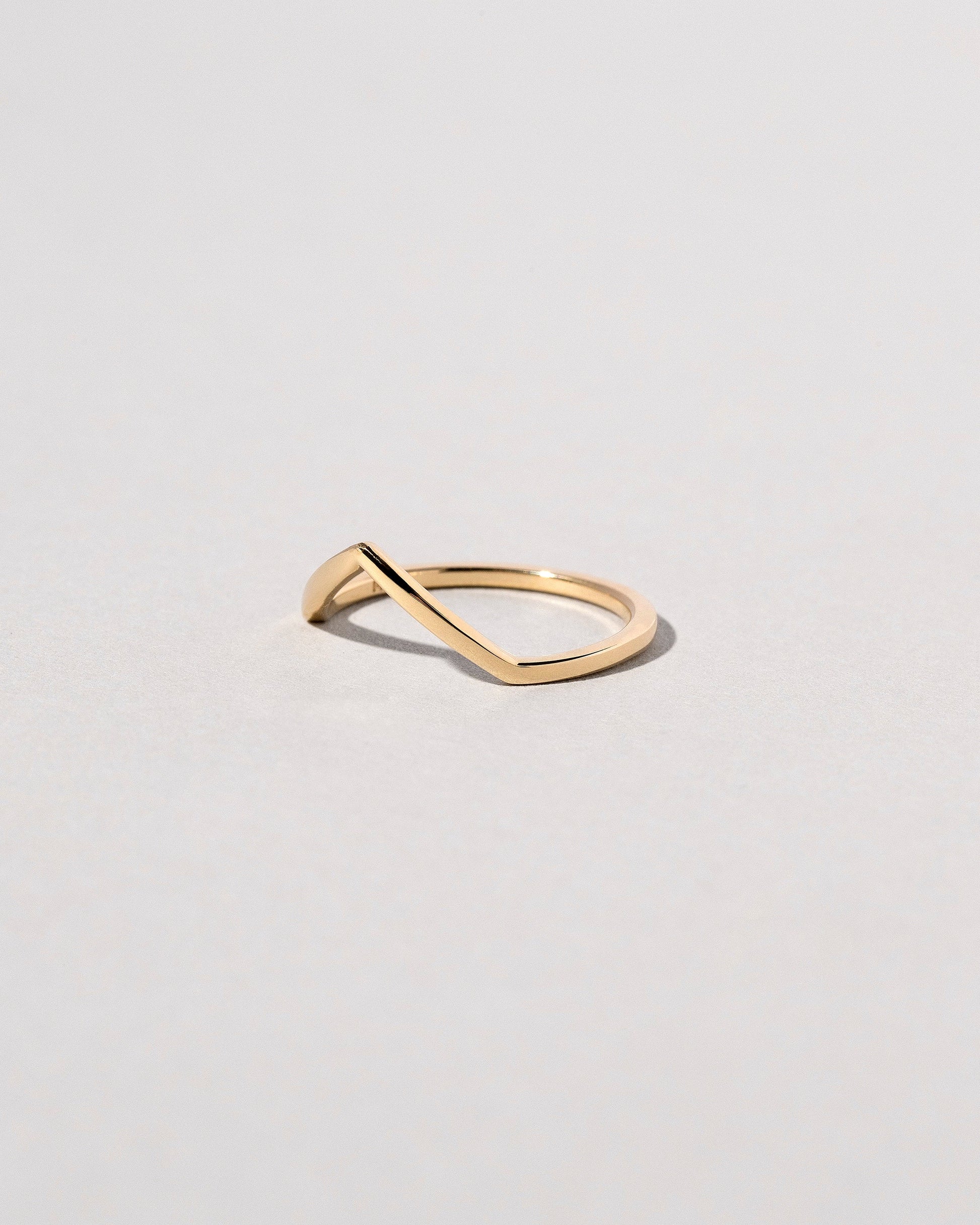 View from the side of the Gold Solid Square Wire High Peak Band on light color background.