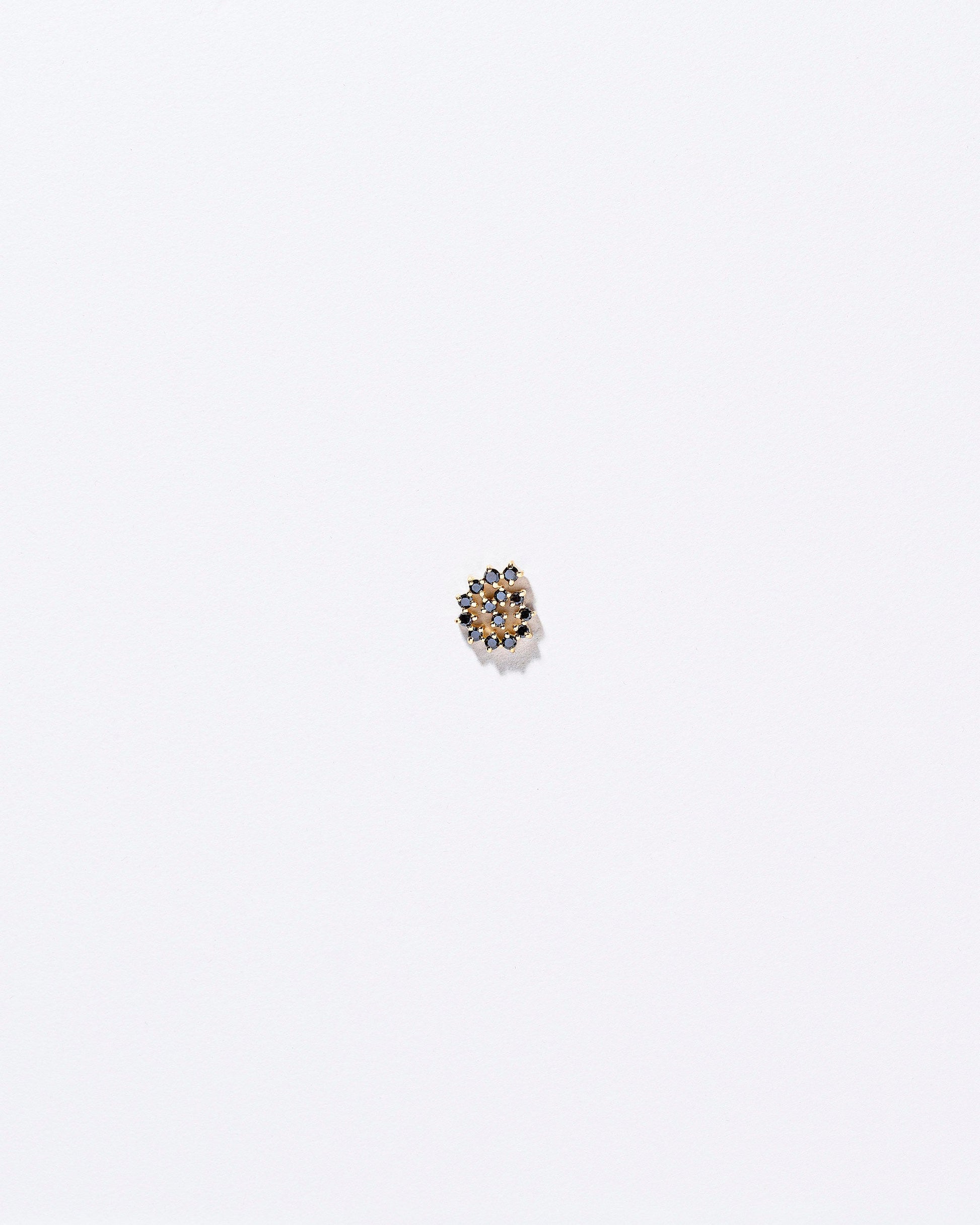 Right Black Diamond Left Spiral Stud Earring Single on light color background.