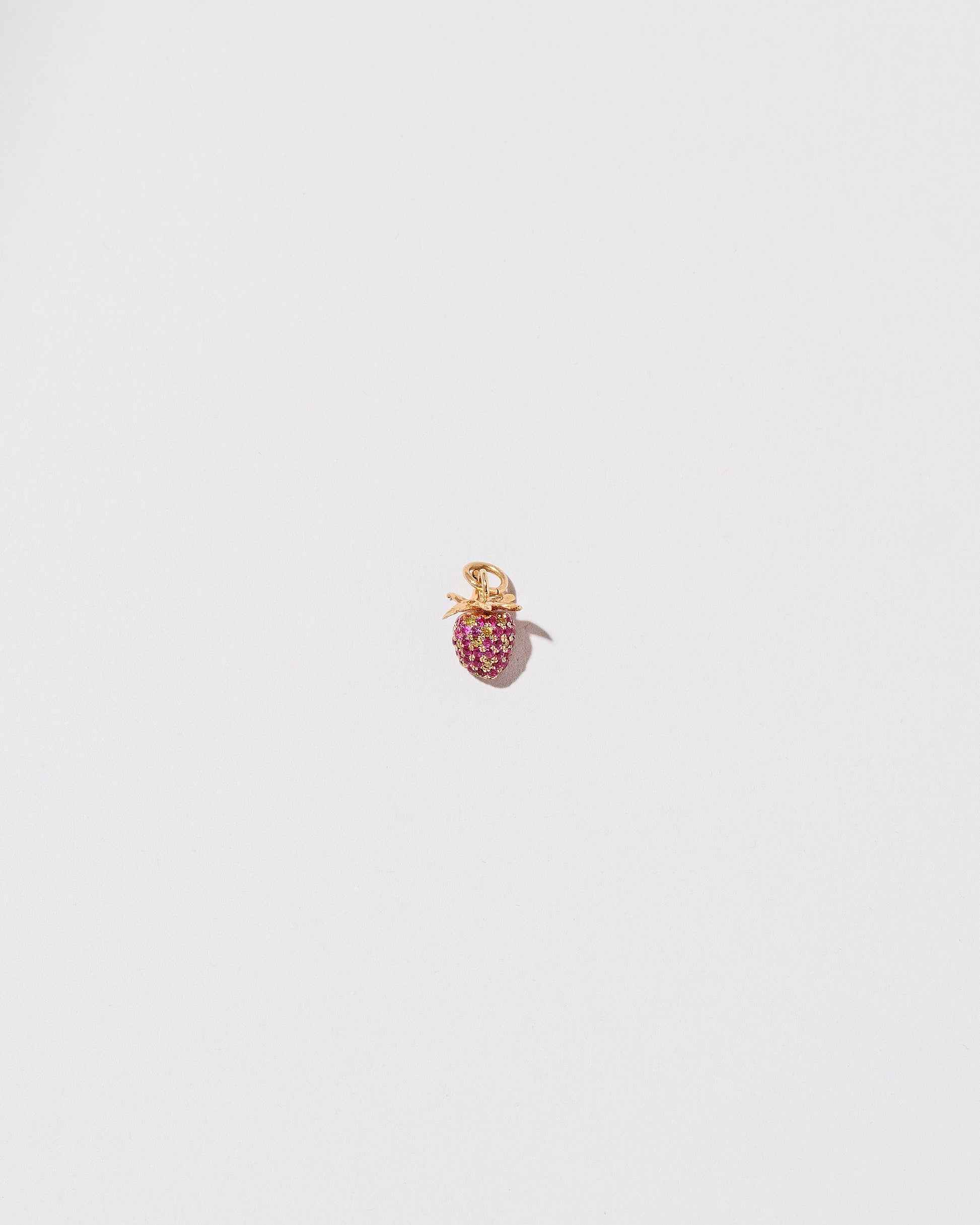 Diamond & Ruby Pavé Strawberry Charm on light color background.