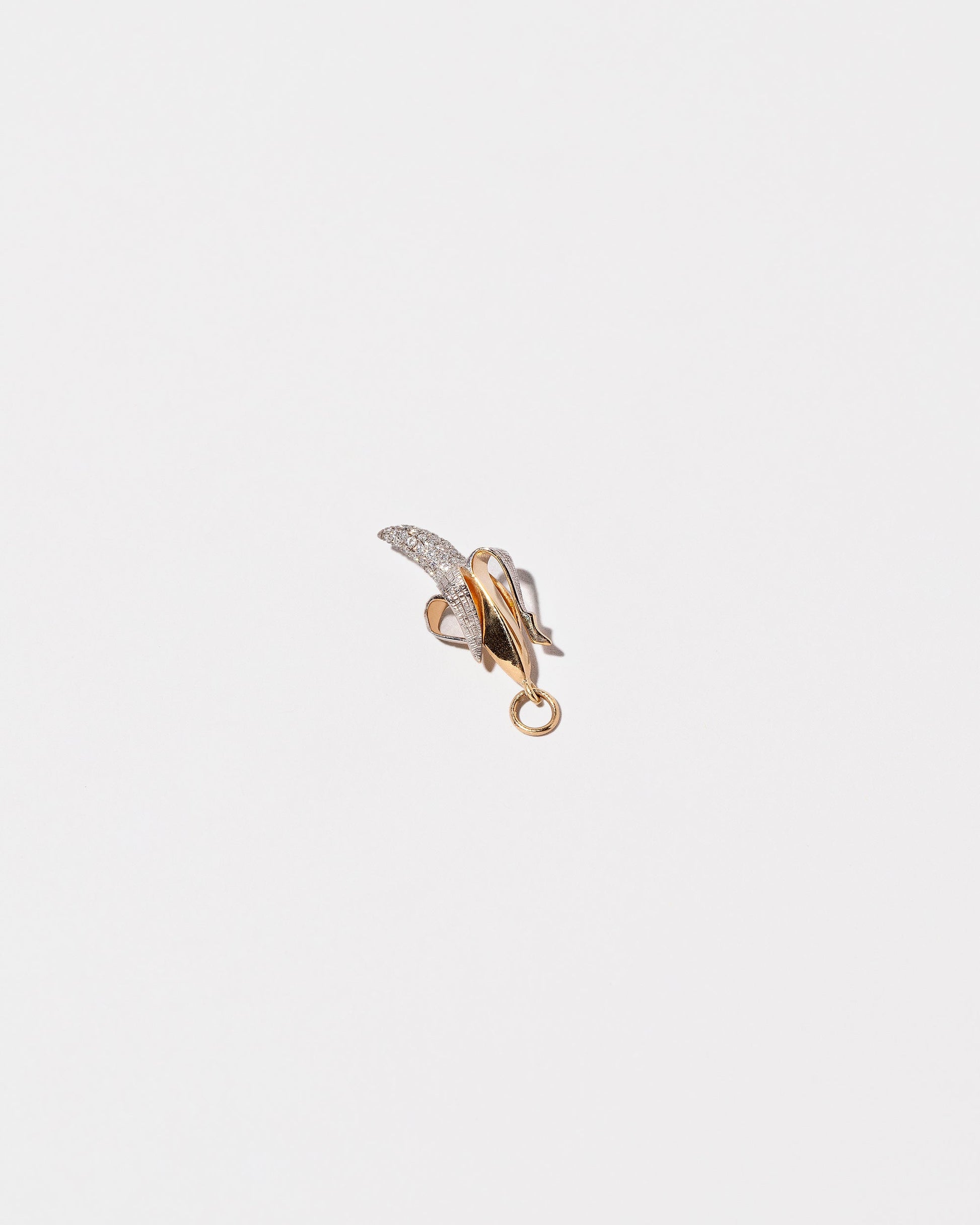View from the side of the Peeled Banana Charm on light color background.