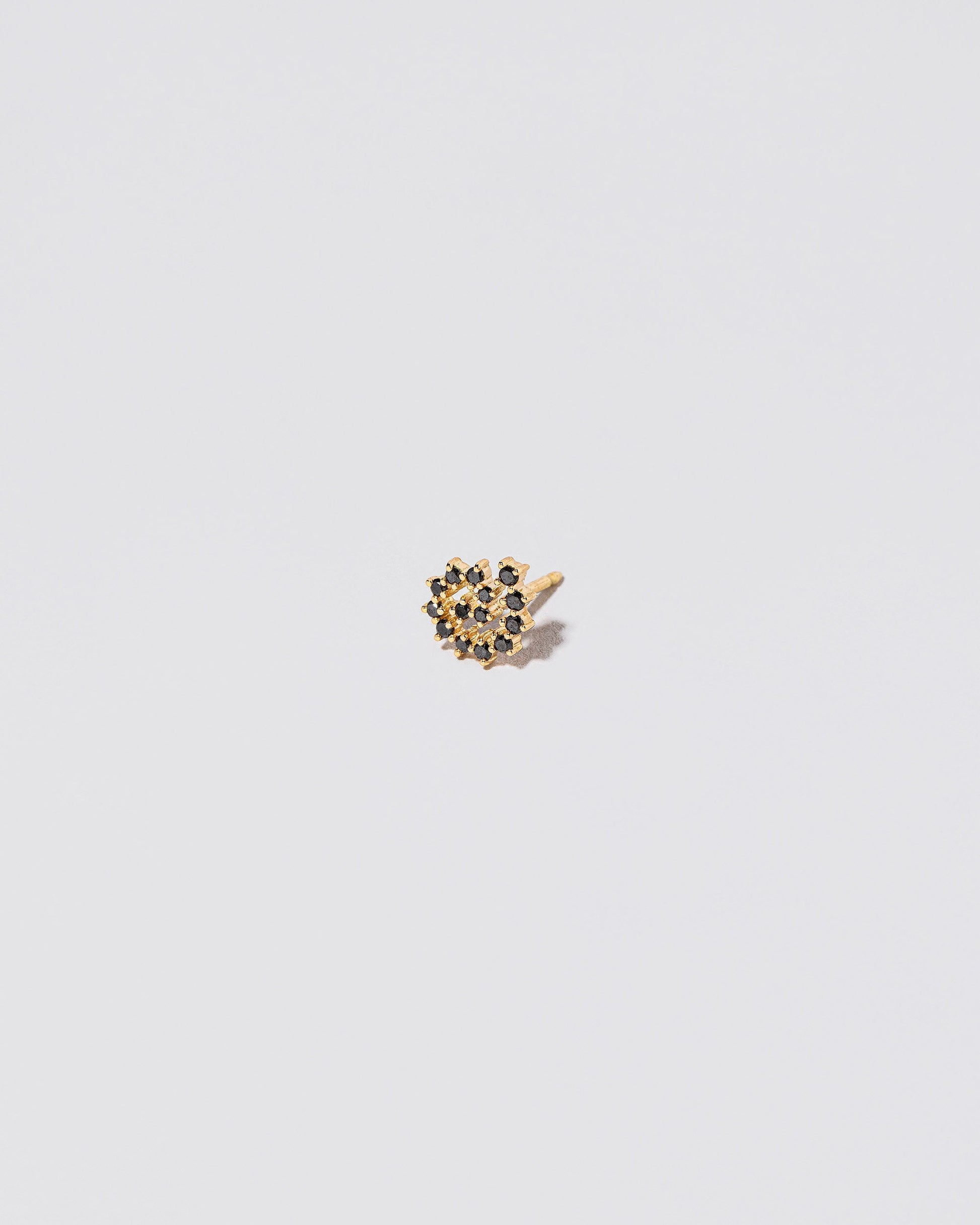 Mini Black Diamond Left Spiral Stud Earring Single on light color background.