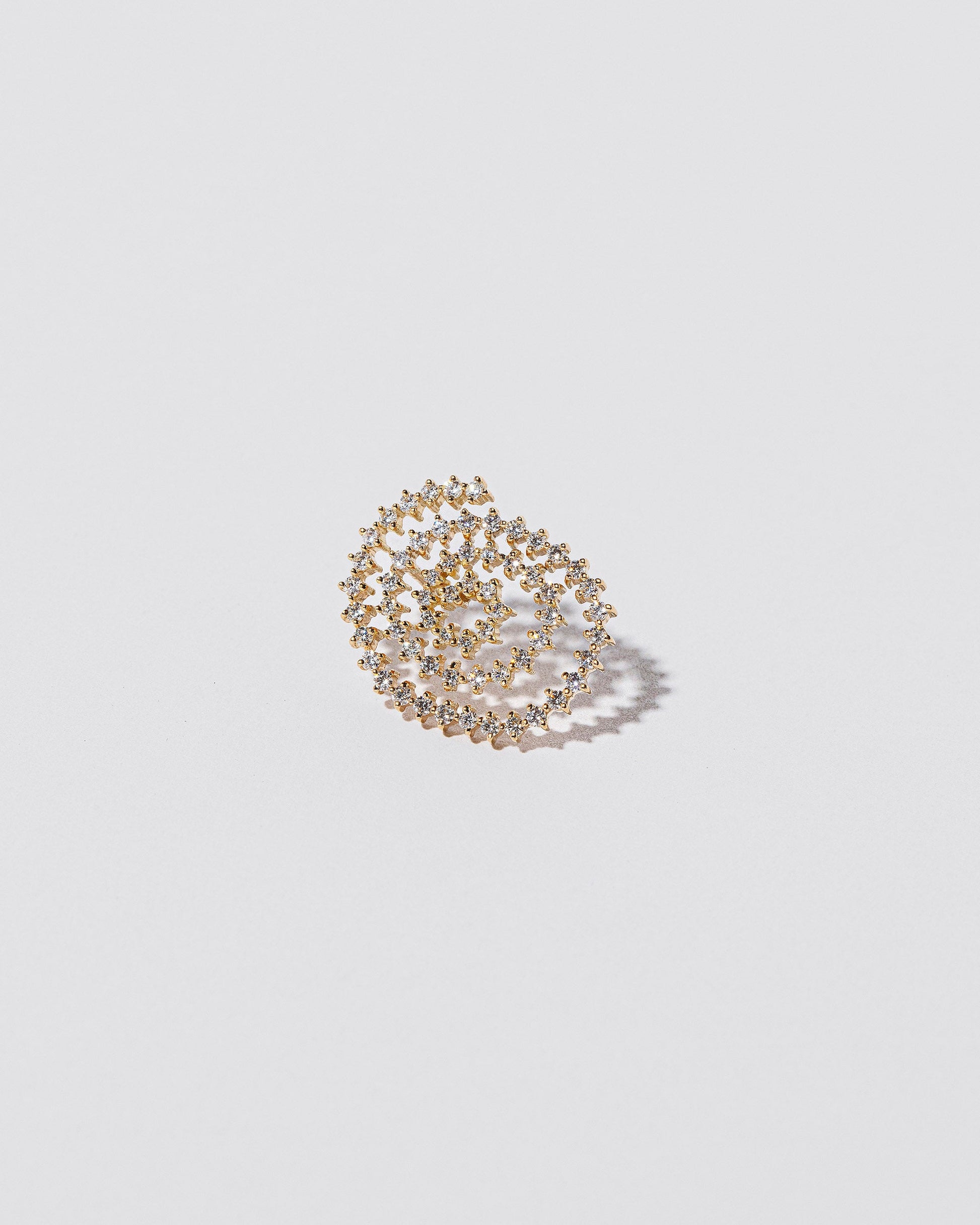 Closeup details of the Right White Diamond Cycle of Rebirth Earring Single on light color background.