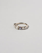 View from the side of the Diamond & Sapphire Line Cluster Ring on light color background.