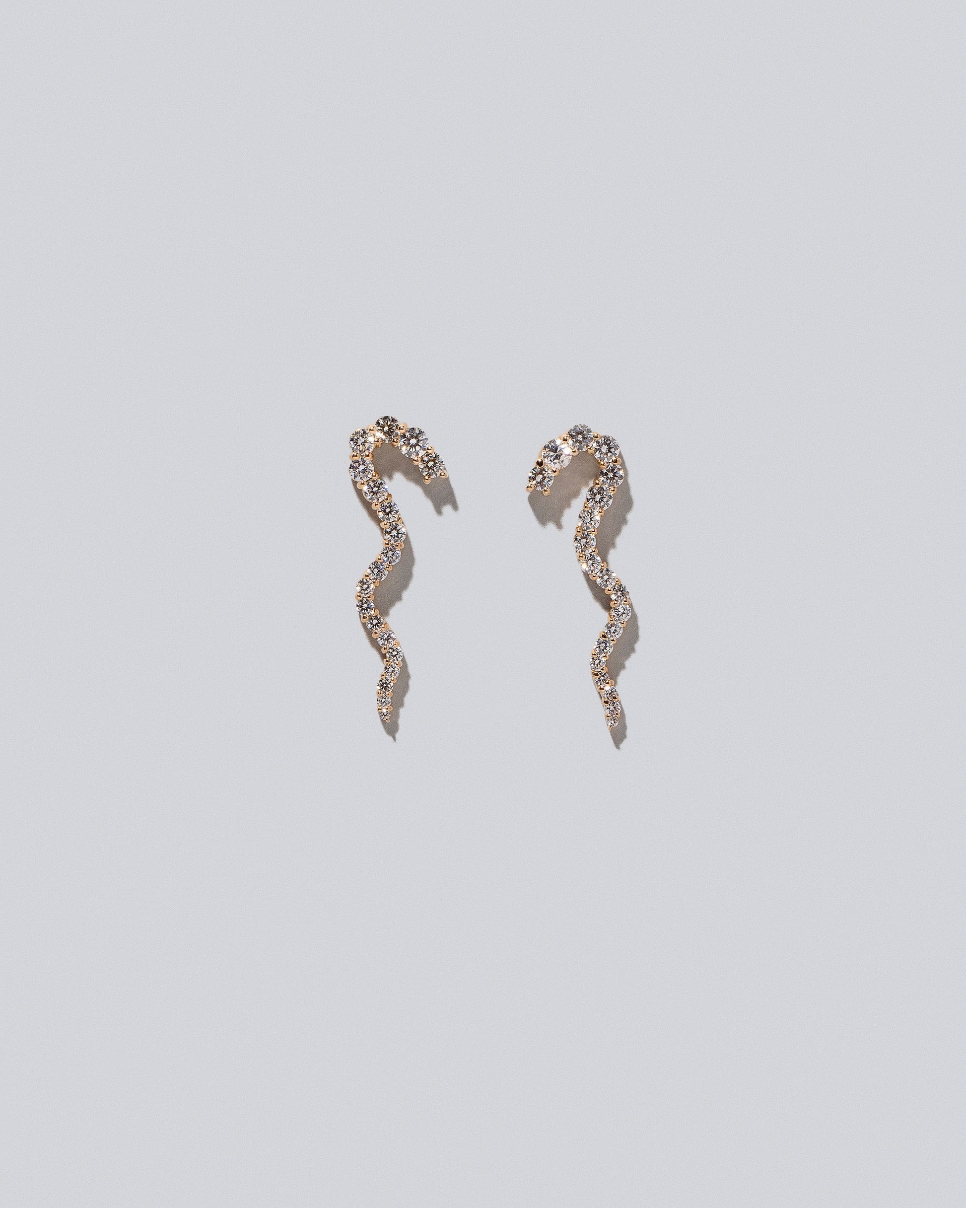 Gold White Diamond Right Ripple Wave Earring Single and Gold White Diamond Left Ripple Wave Earring Single on light color background.