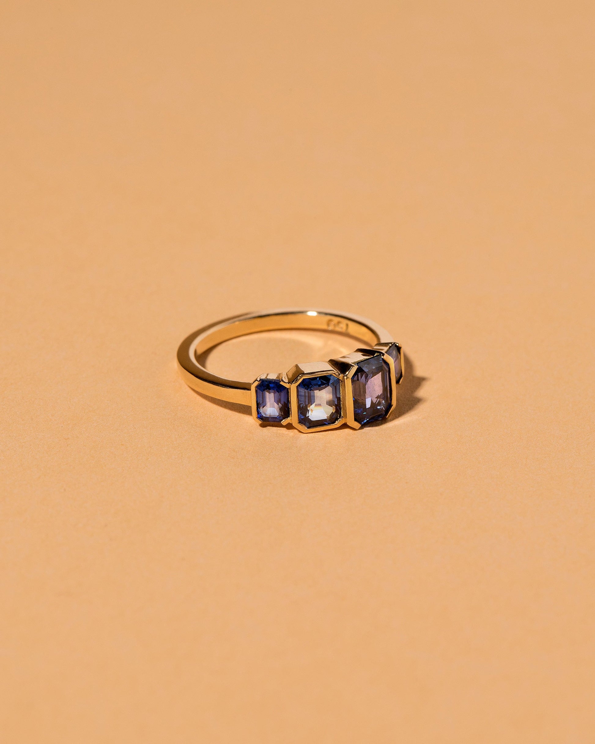 View from the side of the Geometric Sapphire Line Cluster Ring on light color background.
