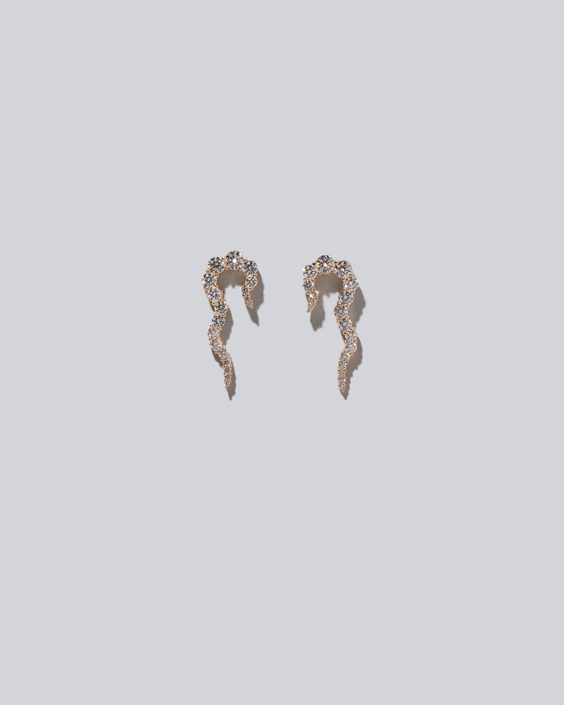 Gold White Diamond Right Tidal Wave Earring Single and Gold White Diamond Left Tidal Wave Earring Single on light color background.