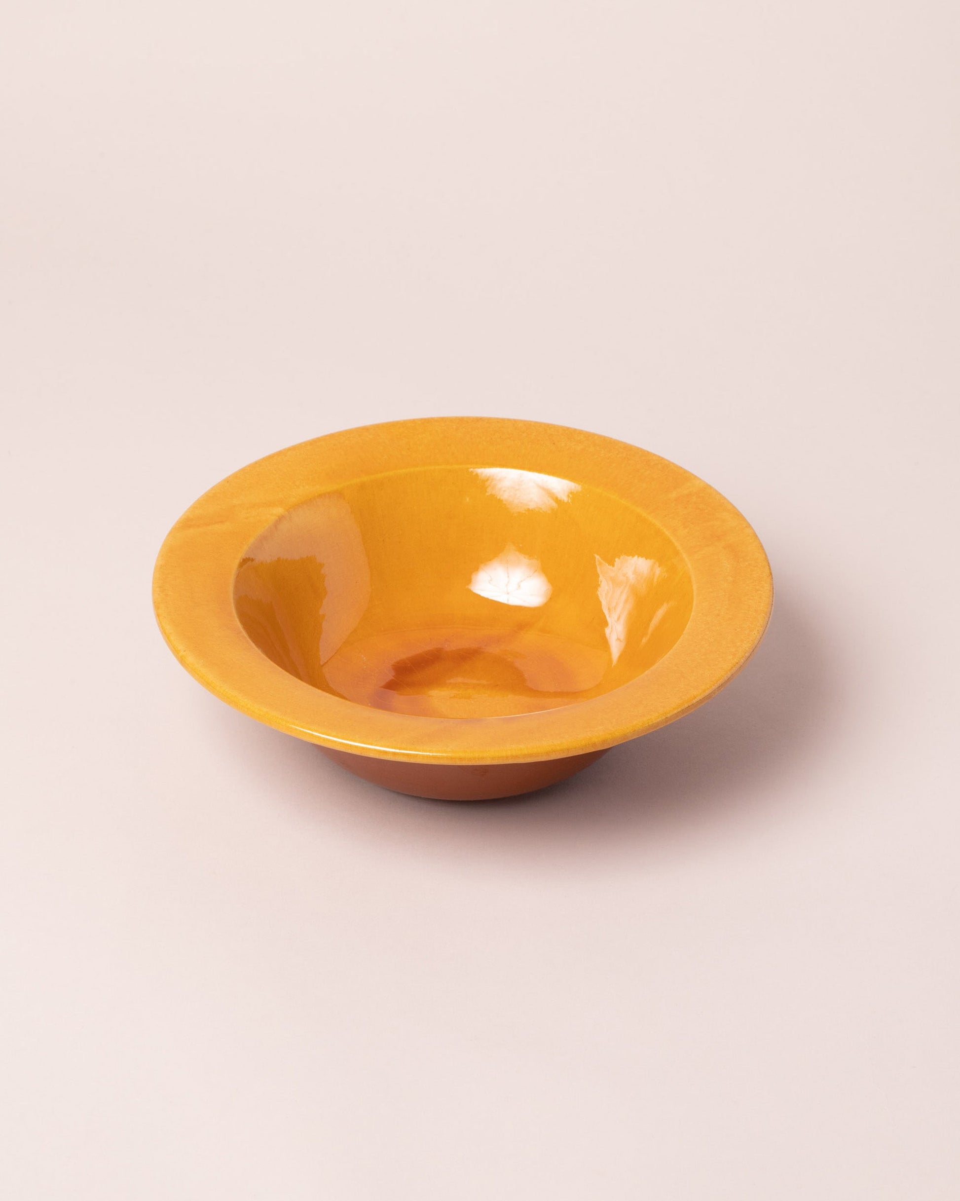 Closeup details of the La Ceramica Vincenzo Del Monaco Caramel Yellow First Course Bowl on light color background.