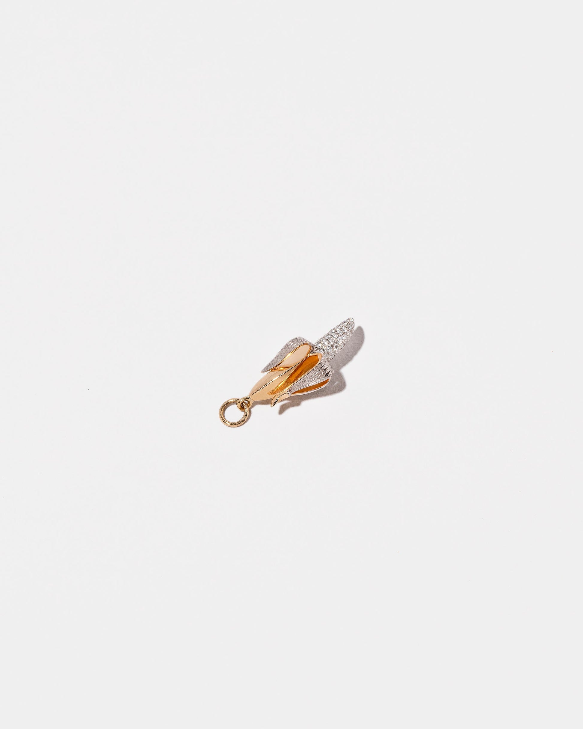 View from the side of the Peeled Banana Charm on light color background.